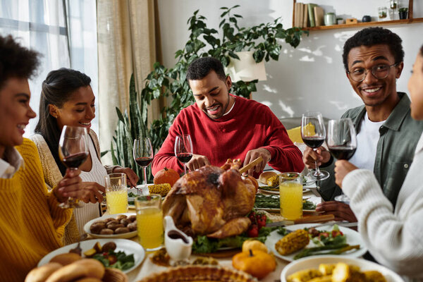 Группа друзей делится смехом и вкусной едой во время празднования Дня Благодарения.