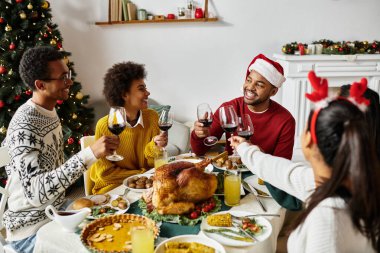 Neşeli bir Noel yemeğinin tadını çıkaran, neşeli bir arkadaş toplantısı..