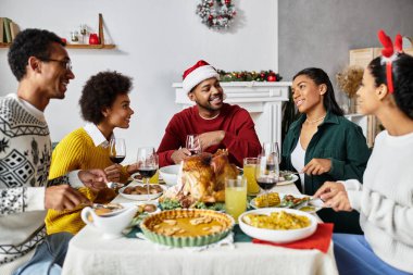 Bir grup arkadaş, neşeli ve neşeli bir Noel yemeği için evde toplanıyor..