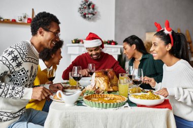Canlı bir grup masanın etrafında toplanıyor, kahkahalarımızı paylaşıyorlar ve lezzetli bir Noel ziyafeti çekiyorlar..
