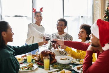 Neşeli arkadaşlar kadehlerini kaldırırken birlikte Noel ziyafetinin tadını çıkarıyorlar..