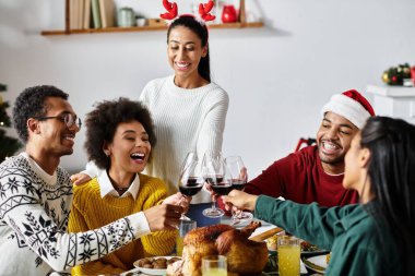 Bir grup arkadaş, neşeli bir Noel yemeğinin tadını çıkarırken kahkahalar ve kadeh kaldırır..