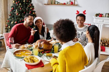Dostlar güzel bir masada toplanır, Noel 'i neşe ve kahkaha ile kutlarlar..