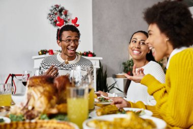 Bir grup arkadaş bir masanın etrafında toplanır ve mutlu bir Noel yemeğinin tadını çıkarırlar..