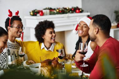 Arkadaşlar neşeyle kahkahaları, şenlikli içkileri ve birlikte bir Noel ziyafetini paylaşırlar..