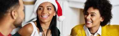 Bir grup arkadaş Noel 'i birlikte kutluyor, evde kahkaha ve tatil ruhunu paylaşıyorlar..