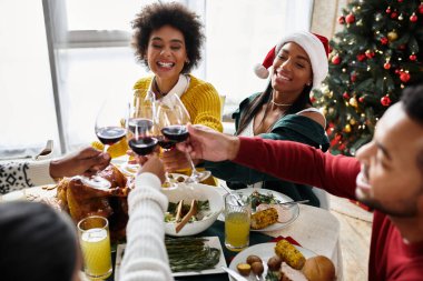 A joyful gathering of friends toasting glasses while enjoying a festive Christmas meal. clipart