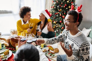 Arkadaşlar evde Noel yemeğinin tadını çıkarırken kahkahalar ve içkileri paylaşırlar..