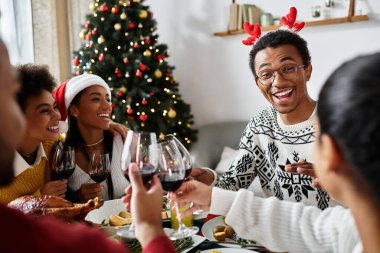 Arkadaşların sıcak bir araya gelip neşe ve neşe dolu bir Noel yemeğinin tadını çıkarması..