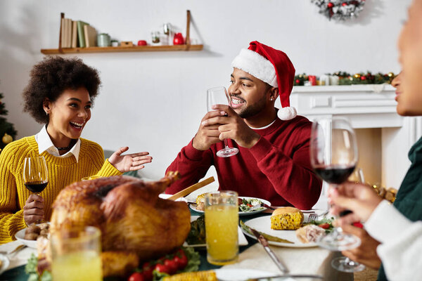 Группа друзей делится смехом, напитками и восхитительным рождественским пиршеством вместе.