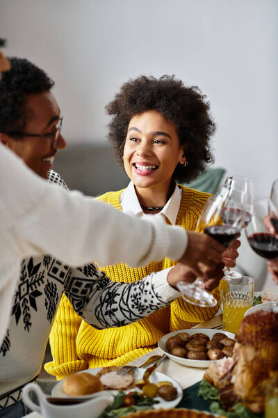 Группа друзей разделяет праздничную трапезу, тосты вместе, празднуя дух праздника.