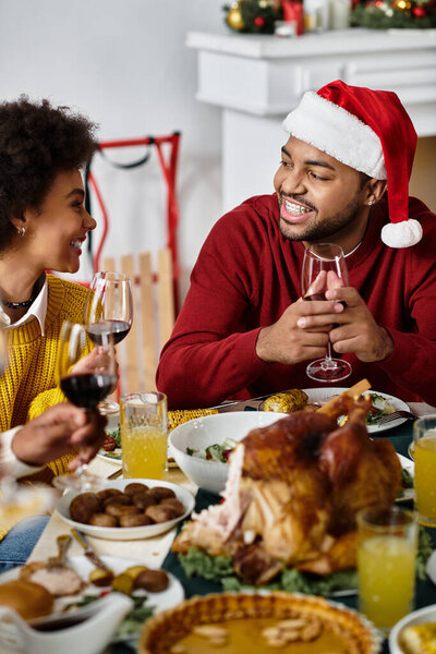 Радостное собрание друзей, празднующих Рождество с вкусной едой и напитками дома.