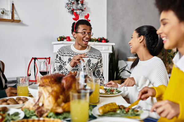 Группа друзей наслаждается праздничным рождественским ужином со смехом и вкусной едой.