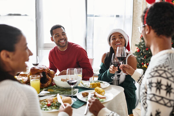 Группа друзей делится праздничной рождественской трапезой, наполненной смехом и хорошим настроением..