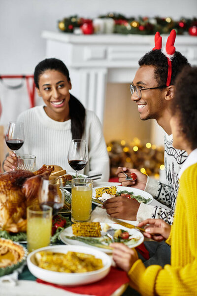 A group of friends enjoys a joyful Christmas meal together at a festive table.