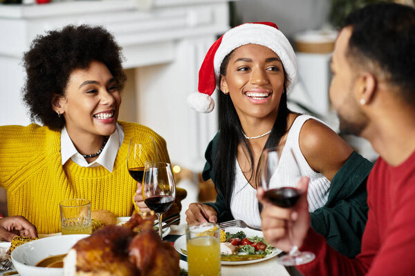 Трое друзей делятся смехом и вкусной праздничной едой во время празднования Рождества вместе.