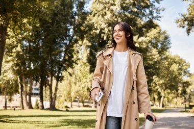 A young woman in cozy autumn attire wanders through a vibrant park filled with golden leaves. clipart