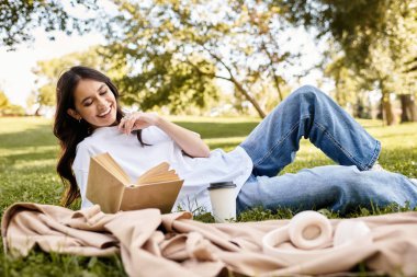 Relaxing on a blanket, a young woman savors her book while basking in autumn sunshine. clipart