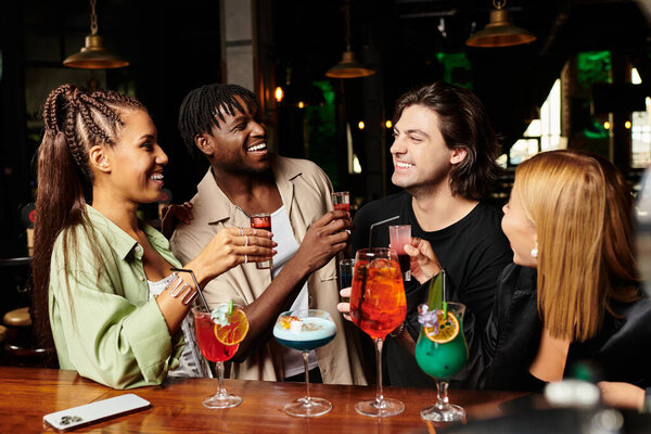 Живая атмосфера, когда молодые профессионалы празднуют вместе, смеются и пьют напитки.