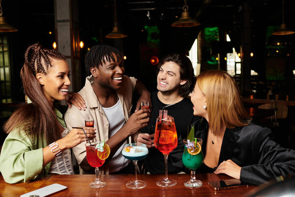 Живое собрание, где коллеги делятся смехом и напитками на корпоративном празднике.