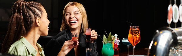 Коллеги наслаждаются яркой атмосферой во время тоста с игривыми коктейлями и смехом.