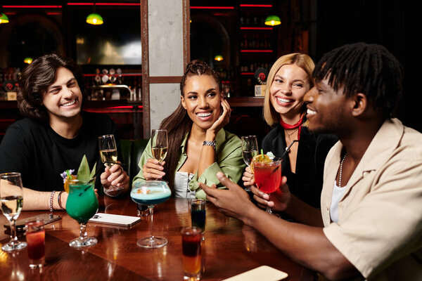 Young professionals enjoy drinks and laughter together at a lively corporate gathering.