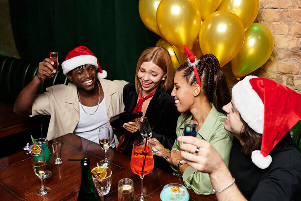 Colleagues enjoy a lively evening at a holiday party, sharing laughter and festive drinks.