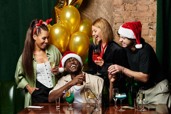 A group of young colleagues celebrates with drinks at a vibrant corporate gathering.