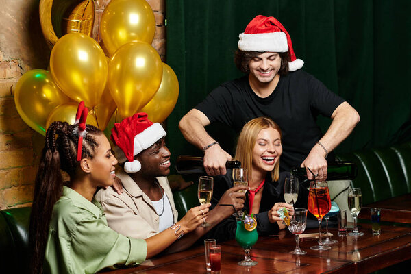 Young colleagues enjoy drinks and laughter while celebrating their success during a corporate party.