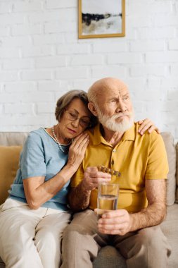 A caring woman comforts her husband with diabetes as they share a quiet moment together. clipart