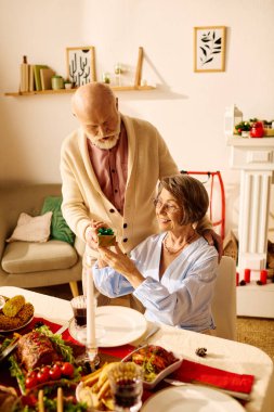 Yaşlı bir çift mutlu bir Noel 'i paylaşıyor, evlerinde hediyelerini paylaşıyorlar..