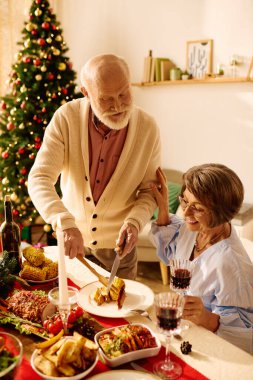 A senior couple enjoys a festive Christmas dinner, surrounded by a beautifully decorated tree. clipart