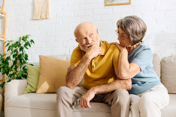 A caring wife offers comfort to her husband as they share an intimate moment at home.