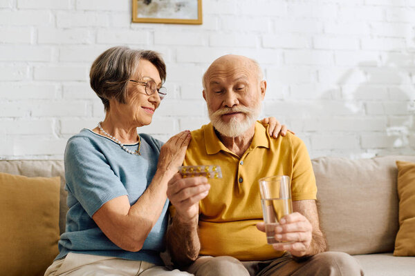 Старшая женщина мягко утешает мужа, пока он готовится принять лекарство..