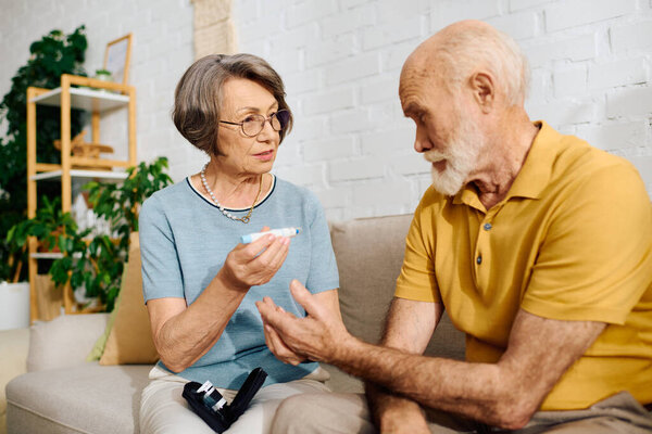 Старшая женщина помогает мужу с сахарным диабетом в их комфортном доме.