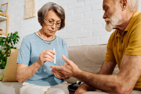 A devoted wife lovingly helps her husband manage diabetes in their cozy home.