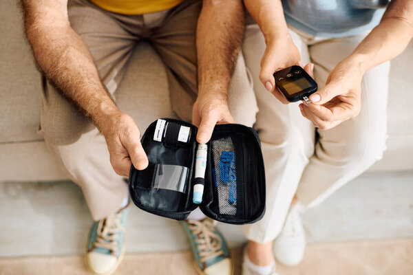 A loving couple supports each other at home while managing diabetes with care and compassion.