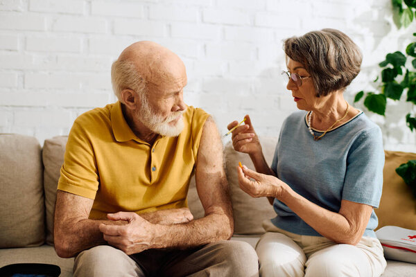 A devoted wife assists her husband with diabetes as he prepares for his medication at home.