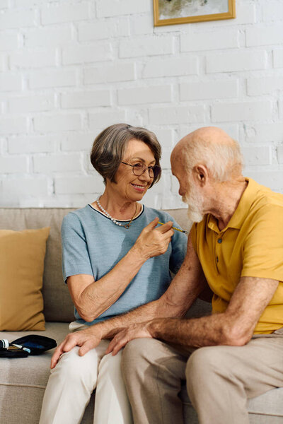 A senior couple enjoys a warm moment at home the wife supports her diabetic husband.