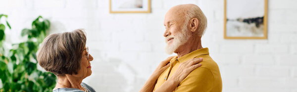 Преданная жена с любовью помогает мужу, разделяя нежный момент дома вместе..