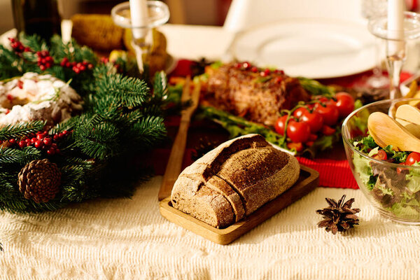 Loaf of fresh delicious bread on Christmas table.