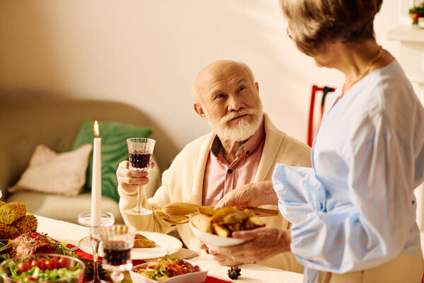 A joyful senior couple enjoys a delightful Christmas dinner together.