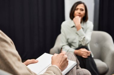 A journalist interviews a specialist, deeply engaged in discussion in a modern studio environment. clipart