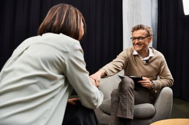 A journalist conducts an insightful interview with a specialist in a modern studio environment. clipart