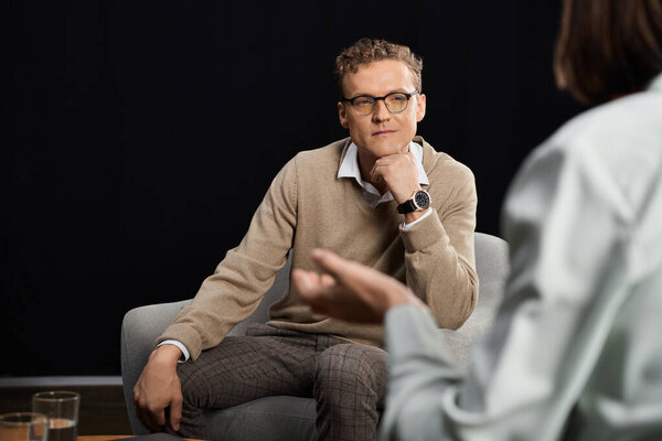 A journalist engages in a profound dialogue with a specialist, exploring important topics in a sleek studio.