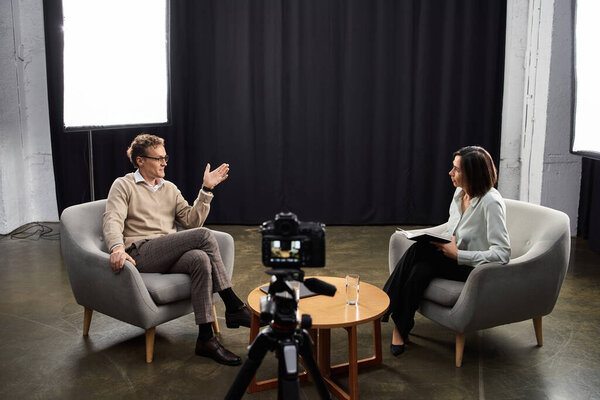 A professional journalist engages in an enlightening discussion with a male specialist in a sleek studio.