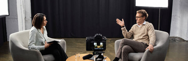 A middle-aged journalist engages a specialist in an insightful interview discussion in an elegant setting.