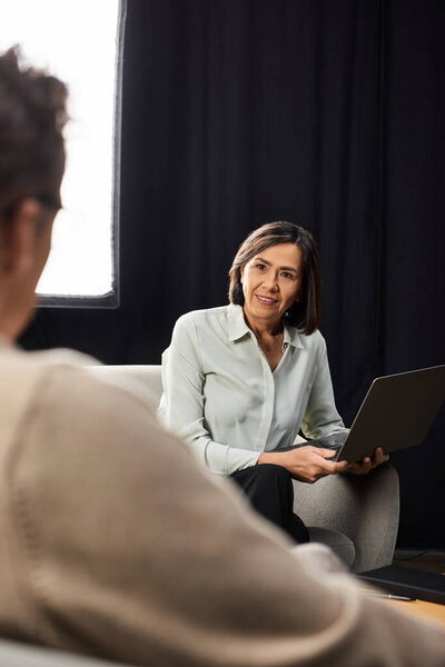 A middle-aged journalist engages in an insightful interview with a male specialist in a warm atmosphere.