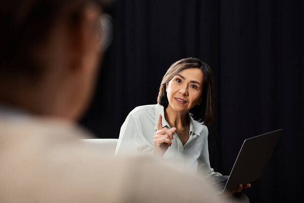 A middle-aged female journalist conducts an insightful interview with a specialist in a professional atmosphere.
