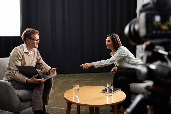 A middle-aged female journalist conducts an insightful interview with a specialist, showcasing professionalism.